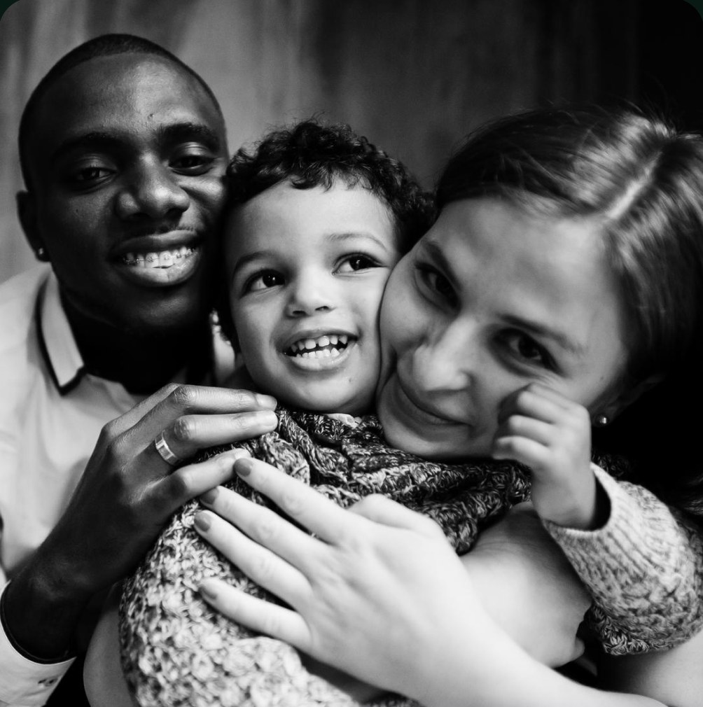 Parents hugging their smiling child